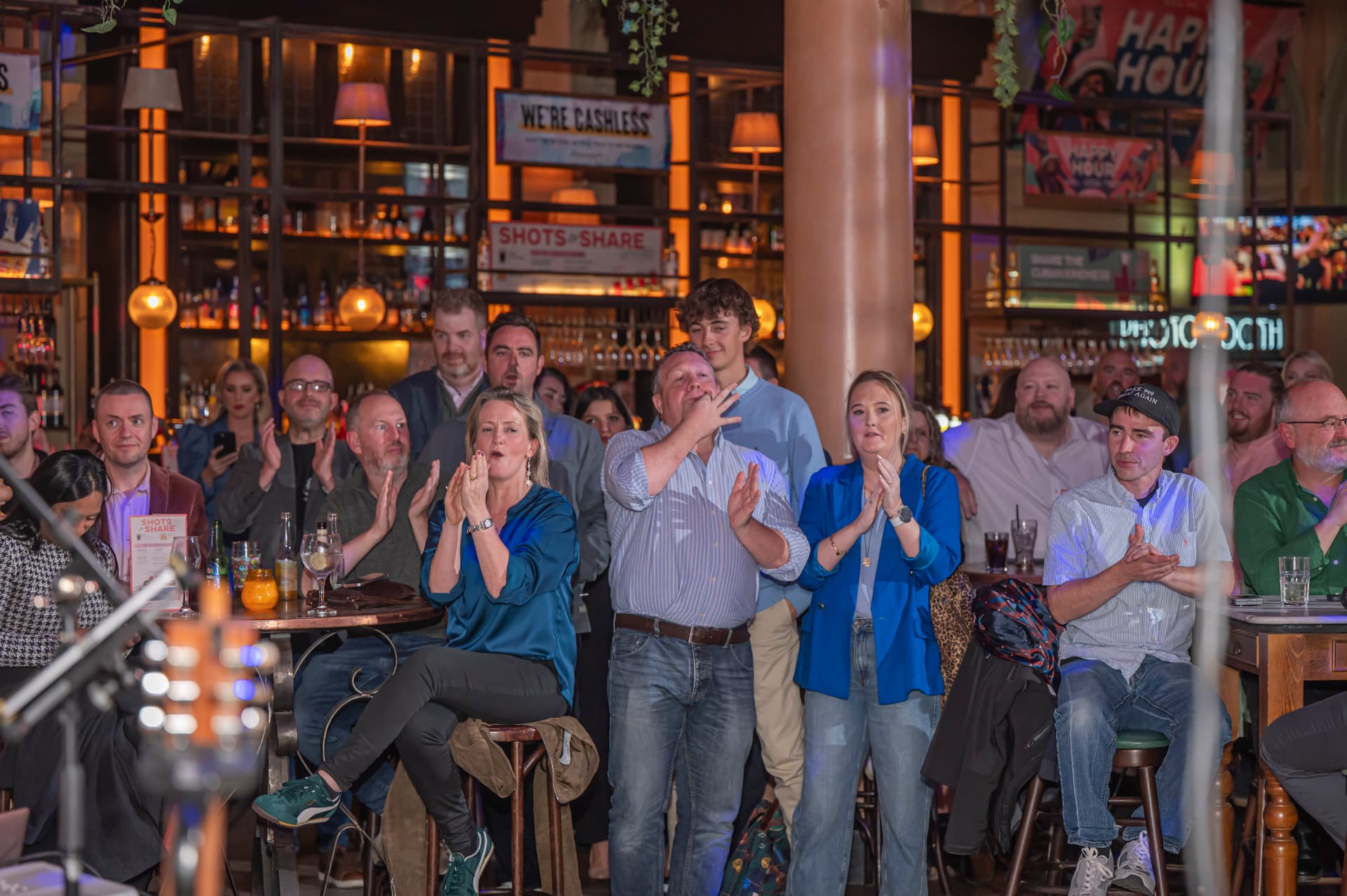 A bar crowd applauding at an evening Belfast Tech Week event